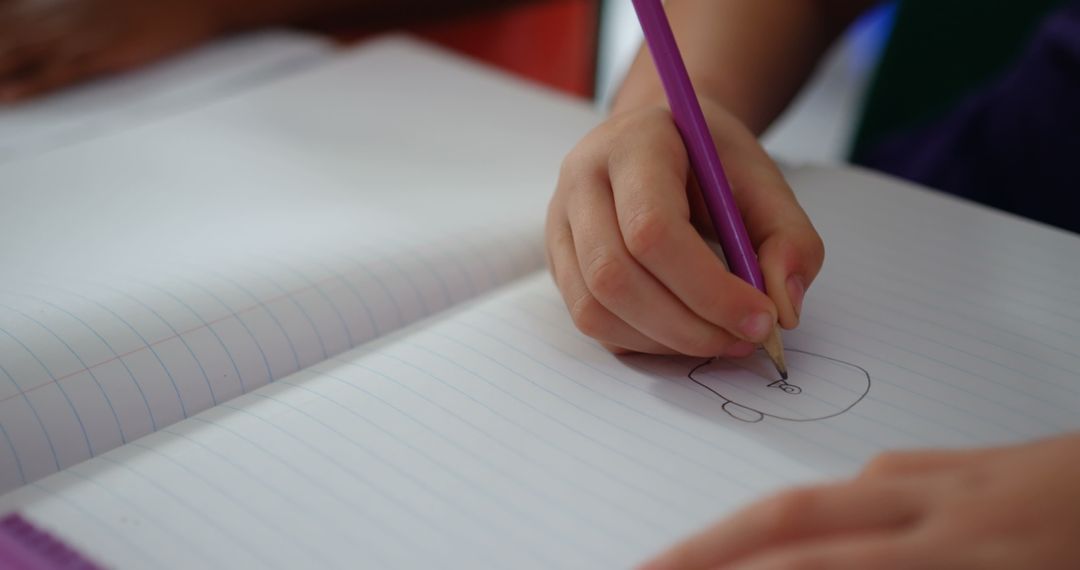 Child Sketching on Notebook in Classroom Setting