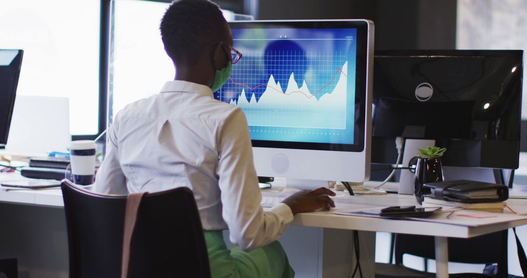 Businesswoman Analyzing Financial Graphs on Desktop Computer in Modern Office - Free Images, Stock Photos and Pictures on Pikwizard.com