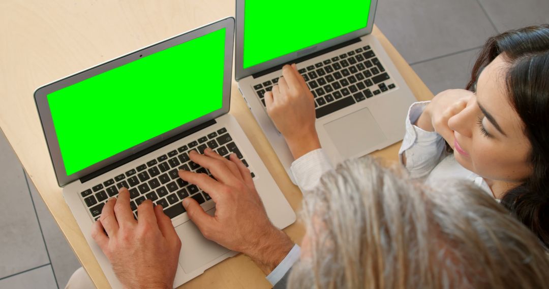 Two People Collaborating on Laptops with Green Screens - Free Images, Stock Photos and Pictures on Pikwizard.com