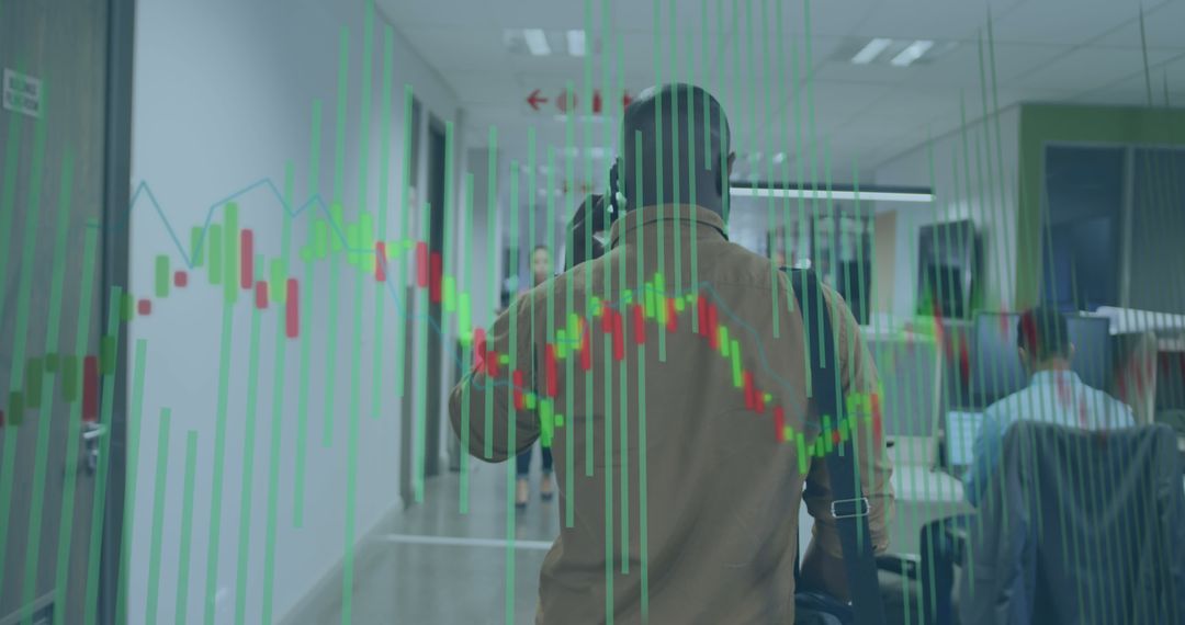 Man Walking in Office Hallway with Financial Graph Overlays - Free Images, Stock Photos and Pictures on Pikwizard.com