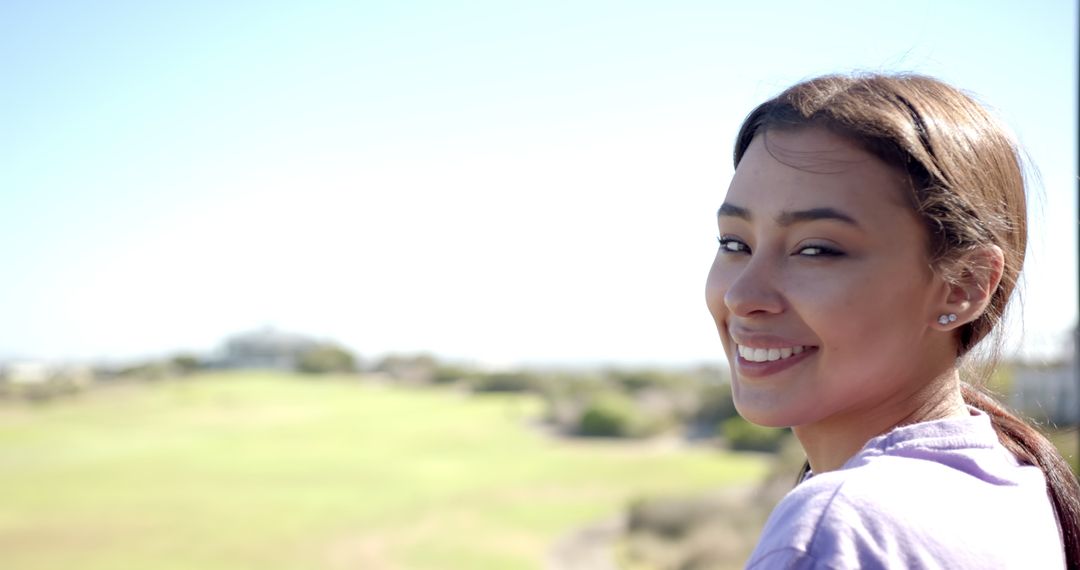 Smiling Woman Enjoying Nature and Sunlight Outdoors