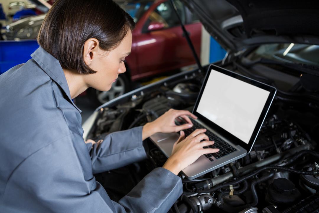 Female mechanic examining car engine with help of laptop - Free Images, Stock Photos and Pictures on Pikwizard.com