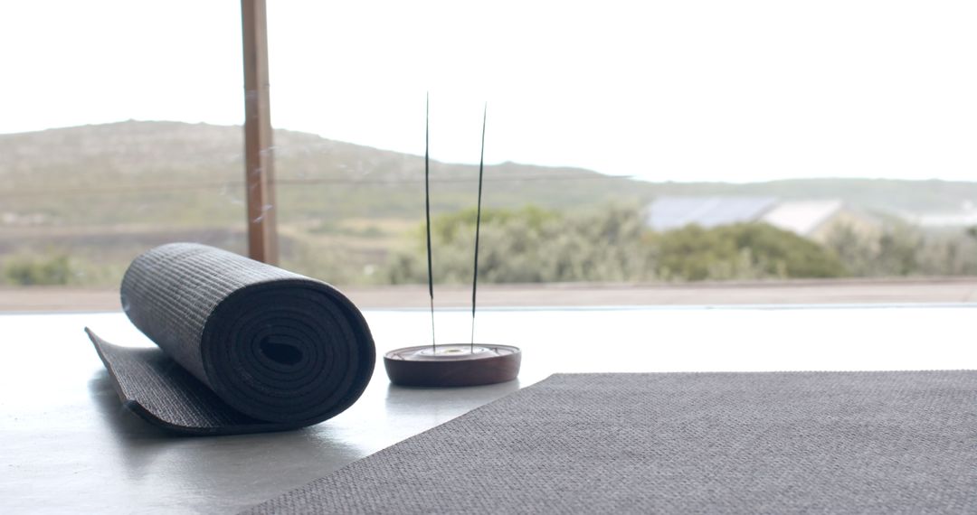 Peaceful Home Yoga Setup with Rolled Mat and Incense
