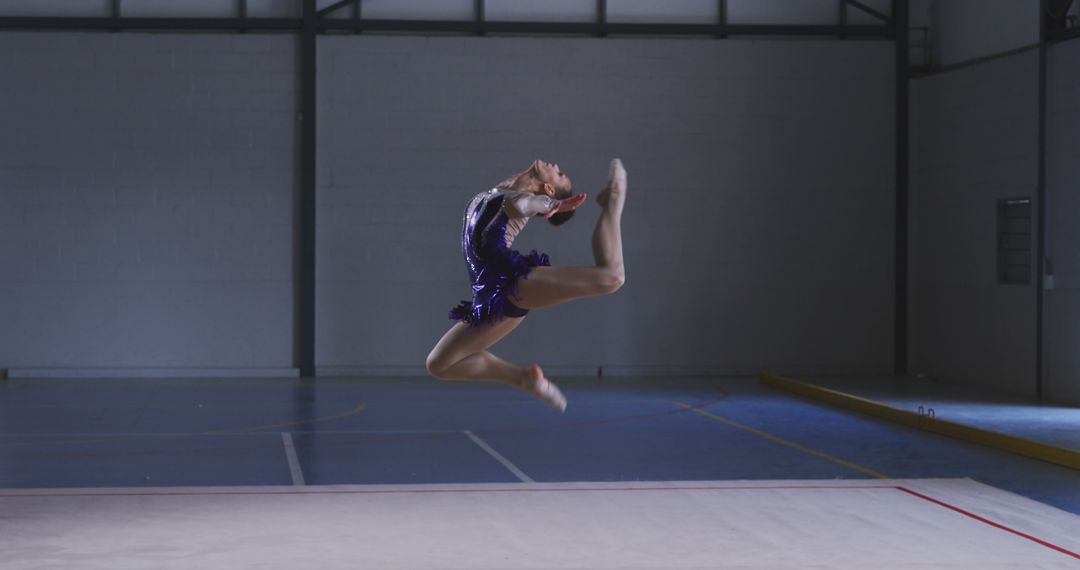 Young Gymnast Leaping in Mid-Air During Floor Routine - Free Images, Stock Photos and Pictures on Pikwizard.com