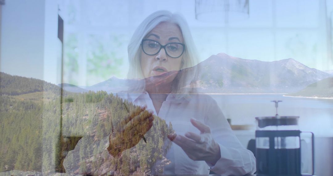 Senior Professional Gesturing in Peaceful Workspace Overlooking Scenic Lake