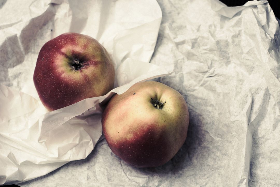 Two Fresh Red Apples on Crumpled White Paper