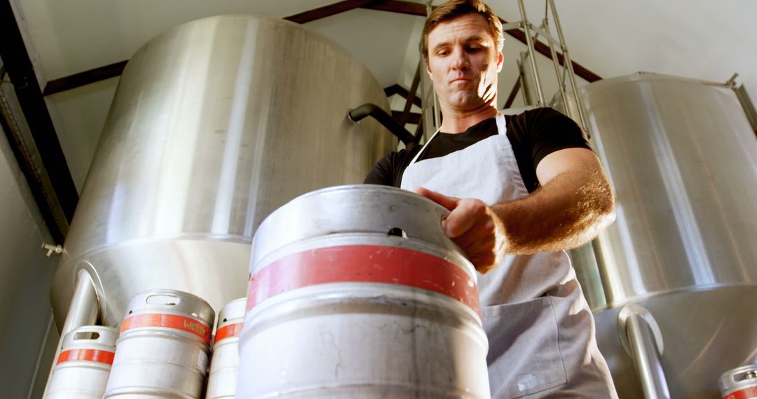 Brewery Worker Inspecting Kegs in Brewery Facility - Free Images, Stock Photos and Pictures on Pikwizard.com