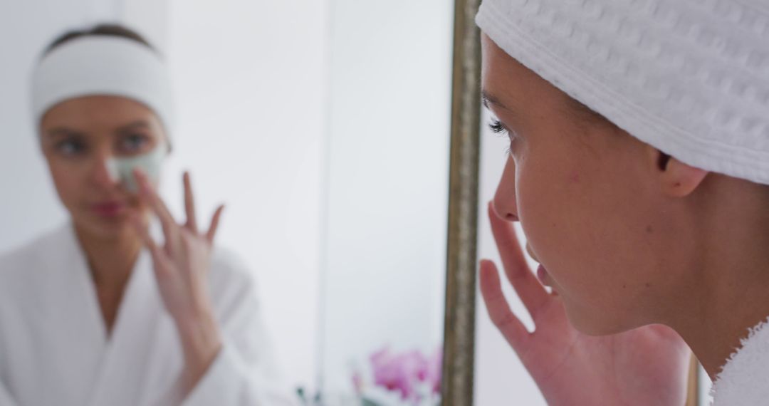 Young Woman Applying Face Mask in Bathroom Mirror Reflection - Free Images, Stock Photos and Pictures on Pikwizard.com