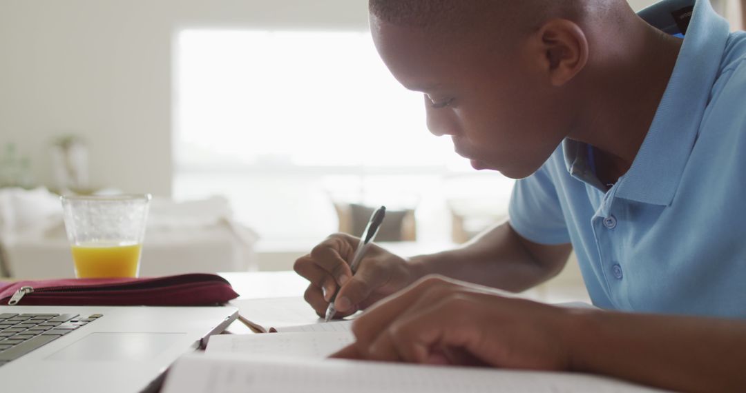 Image of focused african american boy having online lessons at home - Free Images, Stock Photos and Pictures on Pikwizard.com