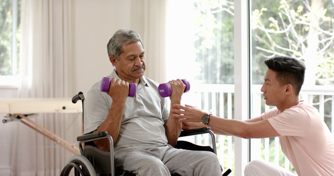 Elderly Man in Wheelchair Exercising with Dumbbells Assisted by Caregiver Indoors - Free Images, Stock Photos and Pictures on Pikwizard.com