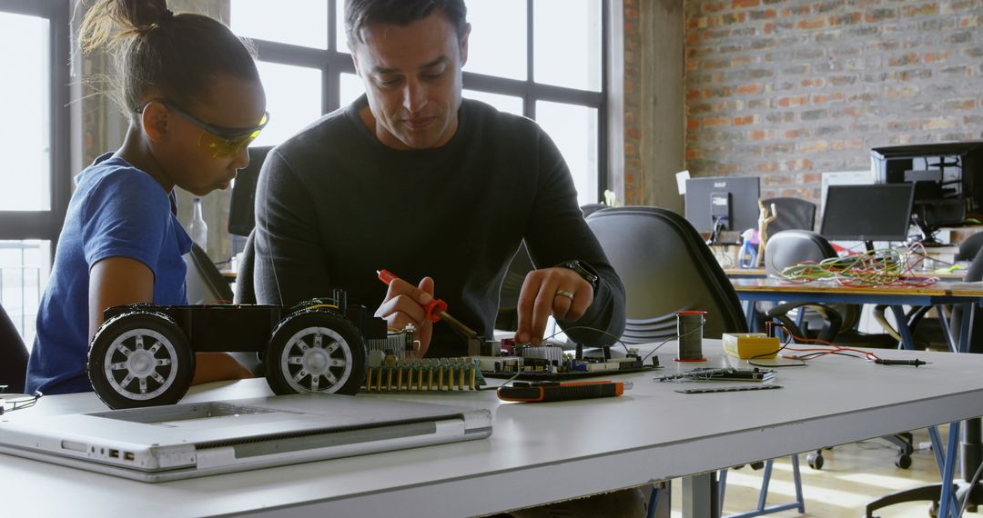 Father and Daughter Engaged in Circuit Board Project for Robotics