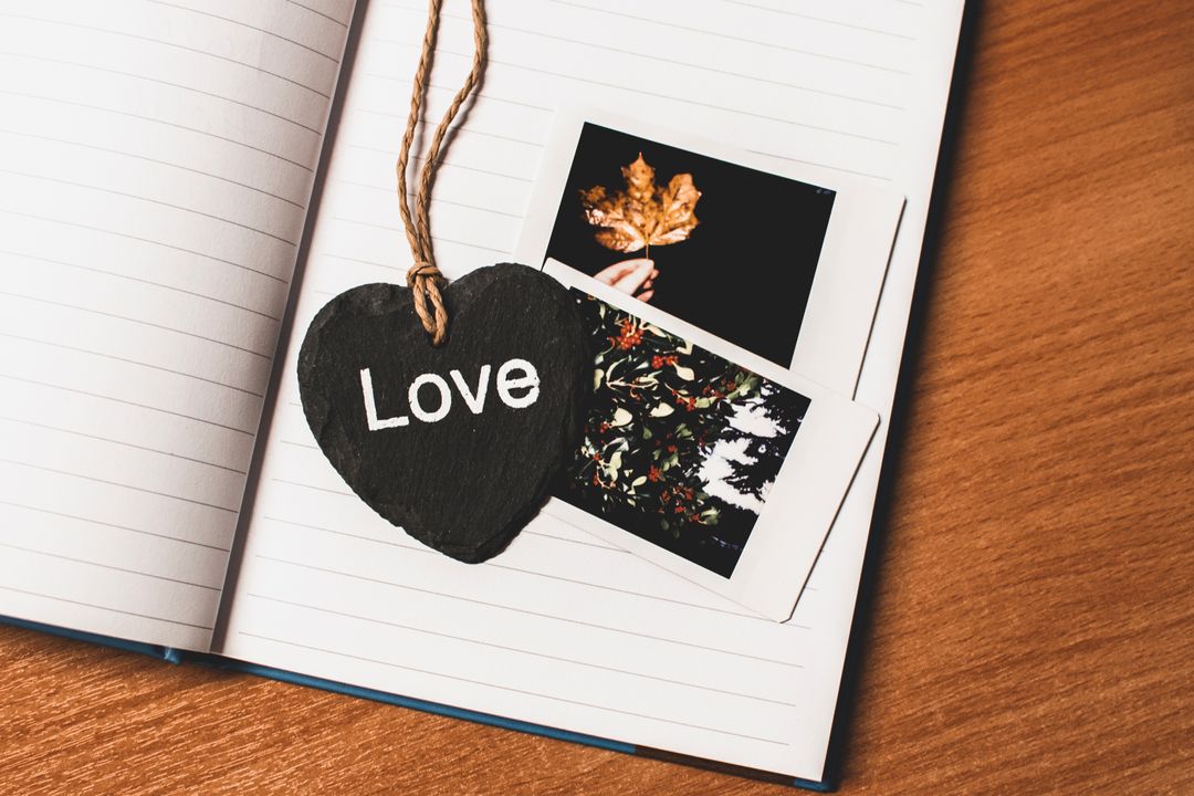 Heart-Shaped Tag on Journal with Instant Photos