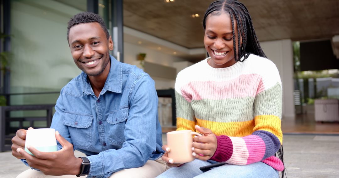 Smiling Couple Enjoying Relaxation with Coffee on Modern Terrace
