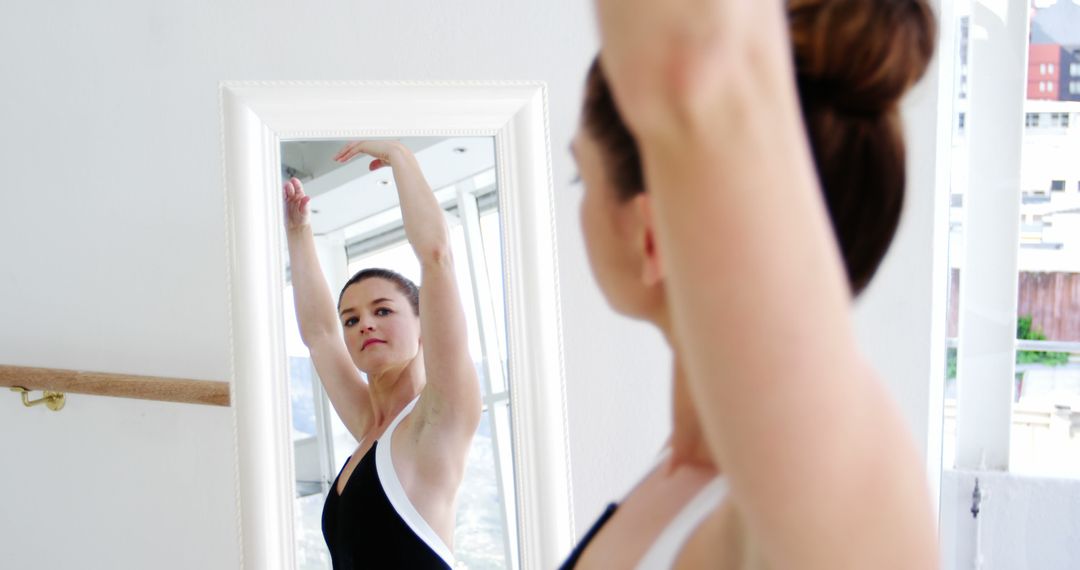 Caucasian Ballerina Perfecting Moves in Front of Mirror