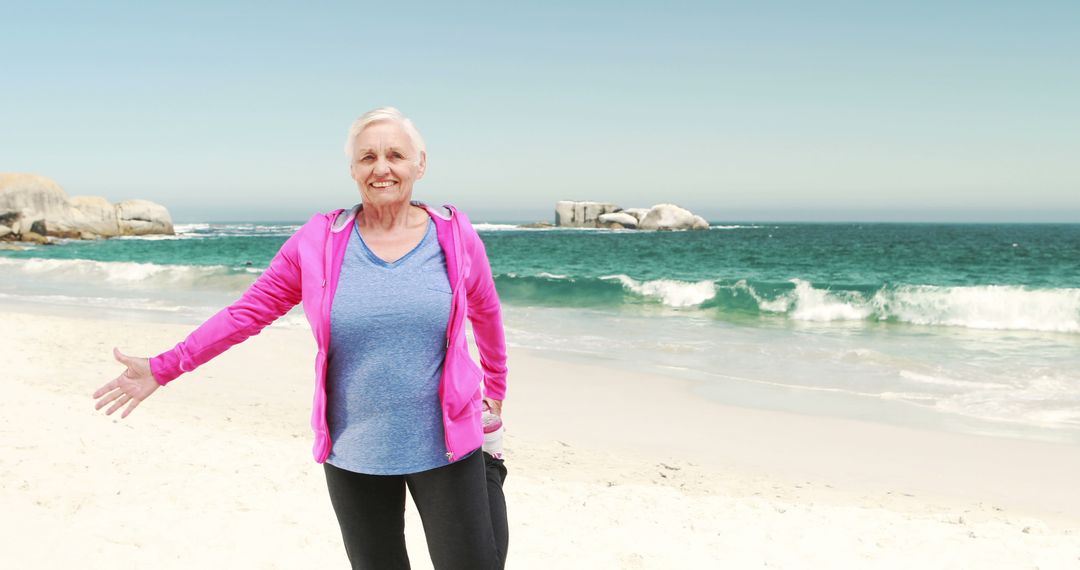 Senior Woman Enjoying Morning on Beach in Pink Jacket - Free Images, Stock Photos and Pictures on Pikwizard.com