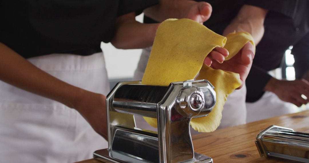 People Making Fresh Pasta with Manual Machine in Kitchen - Free Images, Stock Photos and Pictures on Pikwizard.com