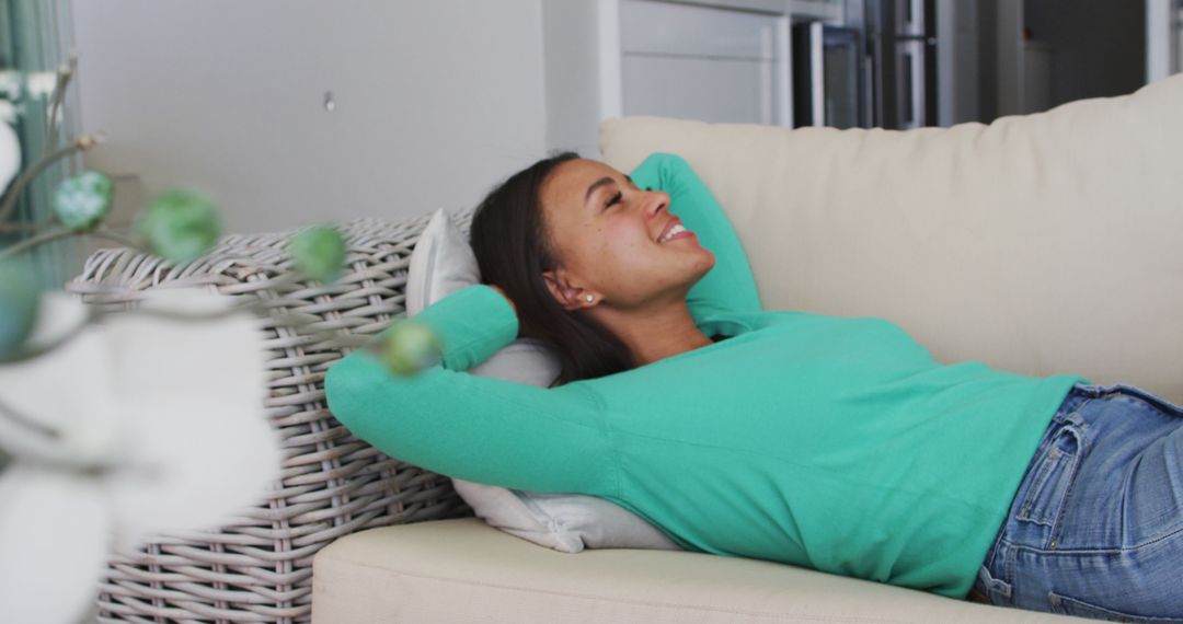 Woman Relaxing on Couch at Home with Arms Behind Head - Free Images, Stock Photos and Pictures on Pikwizard.com