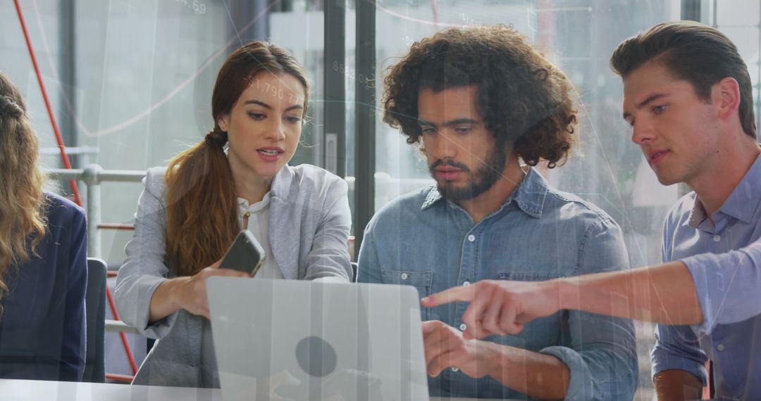 Diverse Team Collaborating on Laptop with Digital Graph Overlay