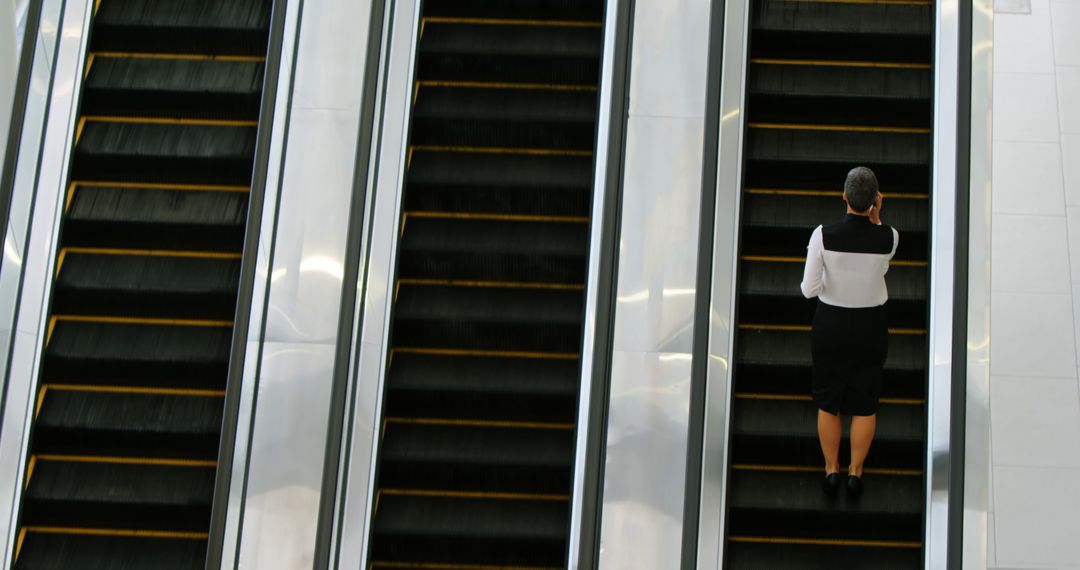 Businesswoman Riding Escalator in Modern Building - Free Images, Stock Photos and Pictures on Pikwizard.com