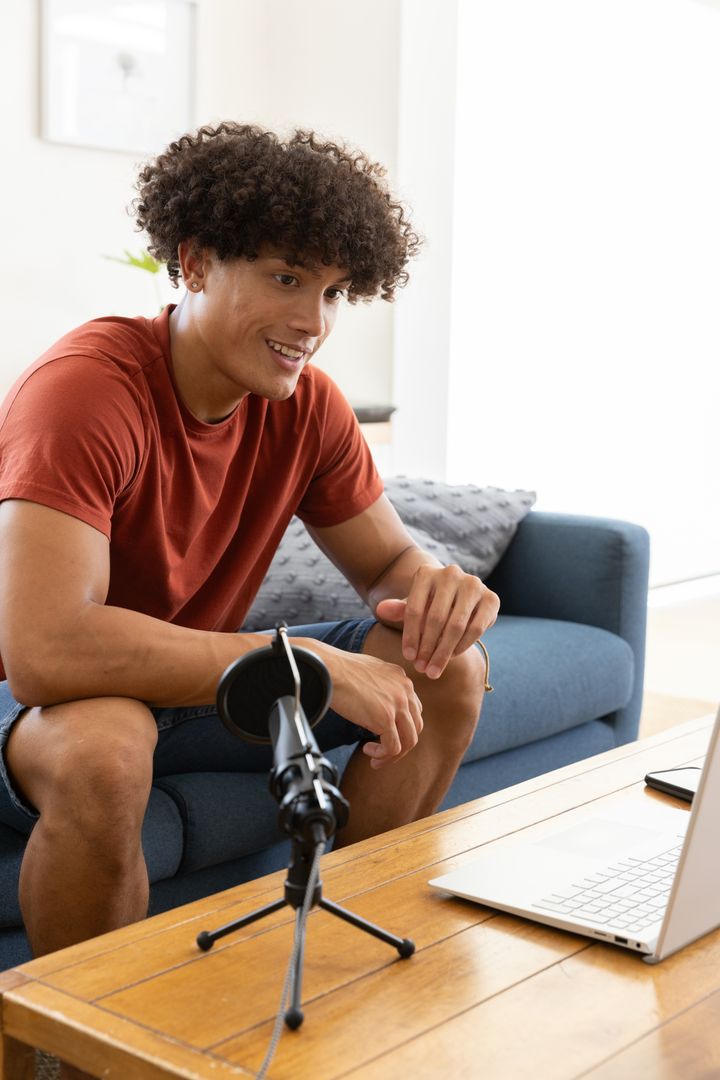 Young Man Recording Podcast at Home with Microphone and Laptop