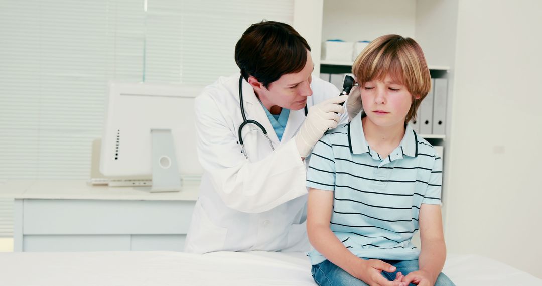 Doctor Examining Young Boy's Ear During Checkup - Free Images, Stock Photos and Pictures on Pikwizard.com