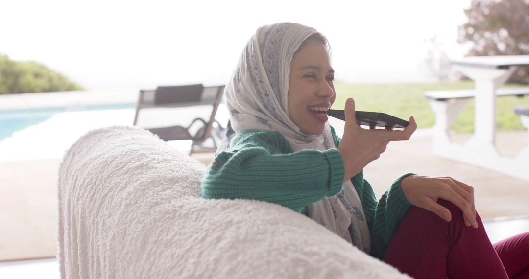 Young Woman in Hijab Enjoying Voice Call on Phone Outdoors - Free Images, Stock Photos and Pictures on Pikwizard.com