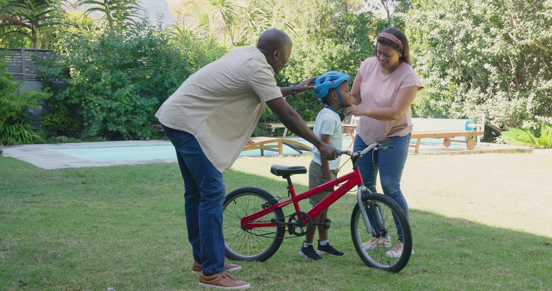 Family Support: Teaching Child to Ride Small Bicycle in Sunny Backyard