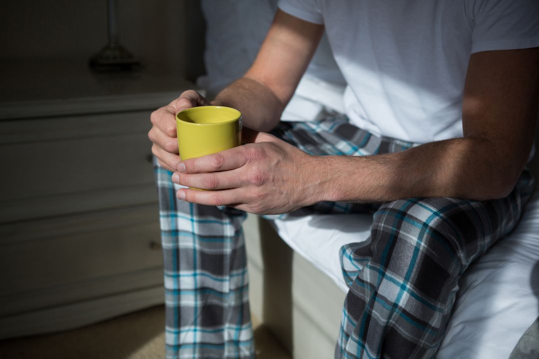 Man having cup of coffee in bedroom - Free Images, Stock Photos and Pictures on Pikwizard.com