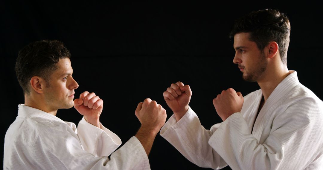 Men practicing karate against black background - Free Images, Stock Photos and Pictures on Pikwizard.com
