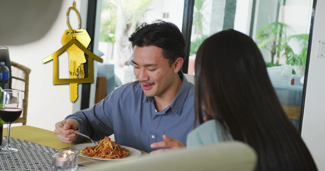 Couple Enjoying Meal at Home with Gold House Key Symbolizing Ownership