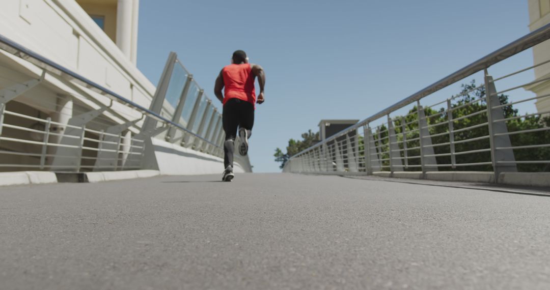 Athletic Man Jogging on Urban Bridge on Sunny Day - Free Images, Stock Photos and Pictures on Pikwizard.com