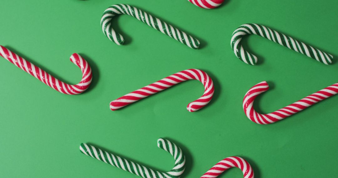 Candy canes on green background for Christmas holiday celebrations - Free Images, Stock Photos and Pictures on Pikwizard.com