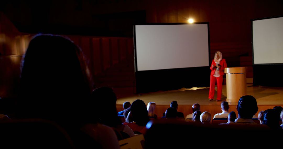 Speaker in Bright Red Suit Delivering Presentation to Engaged Audience - Free Images, Stock Photos and Pictures on Pikwizard.com