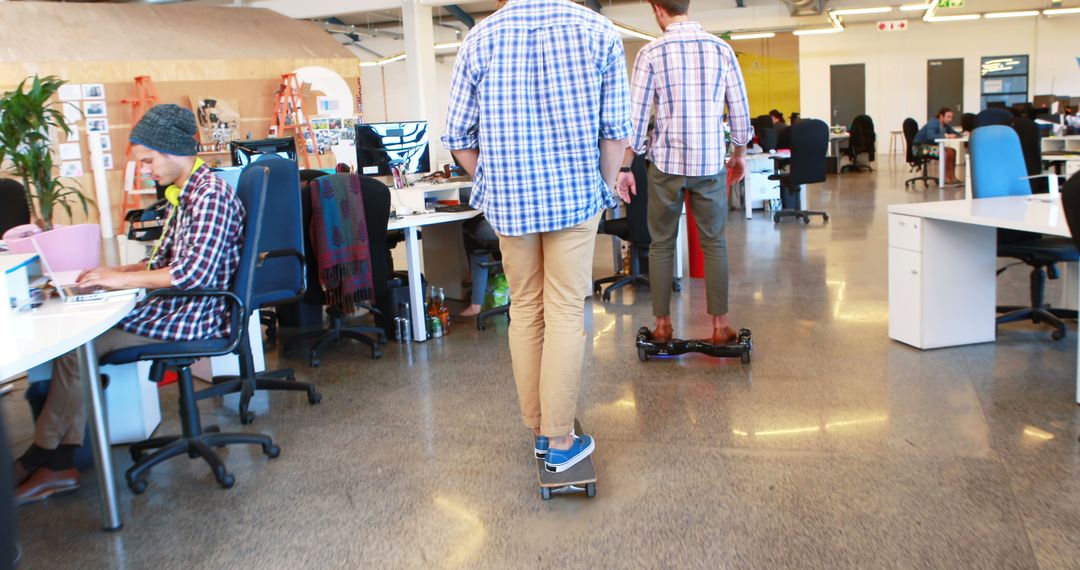 Modern Office with Young Professionals on Skateboards and Hoverboards - Free Images, Stock Photos and Pictures on Pikwizard.com