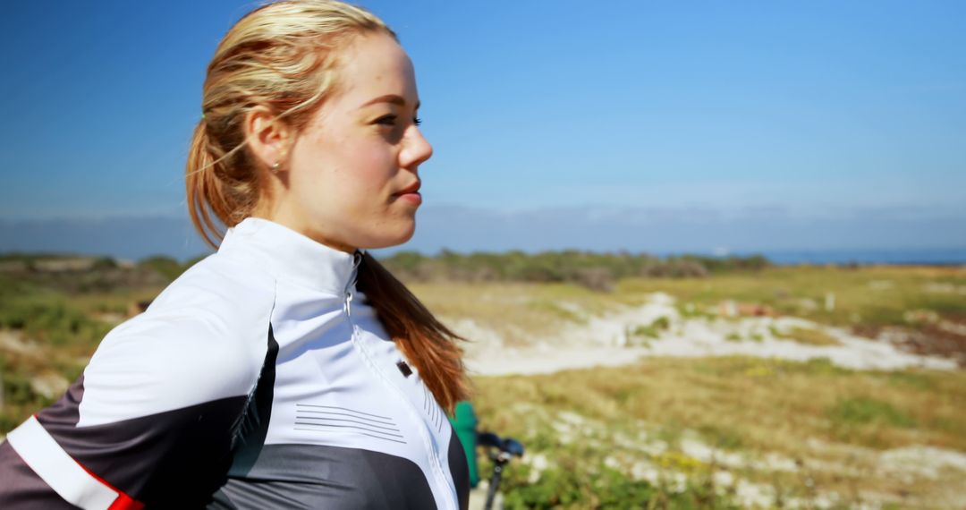 Female Cyclist Enjoying Scenic Coastal View on a Sunny Day - Free Images, Stock Photos and Pictures on Pikwizard.com