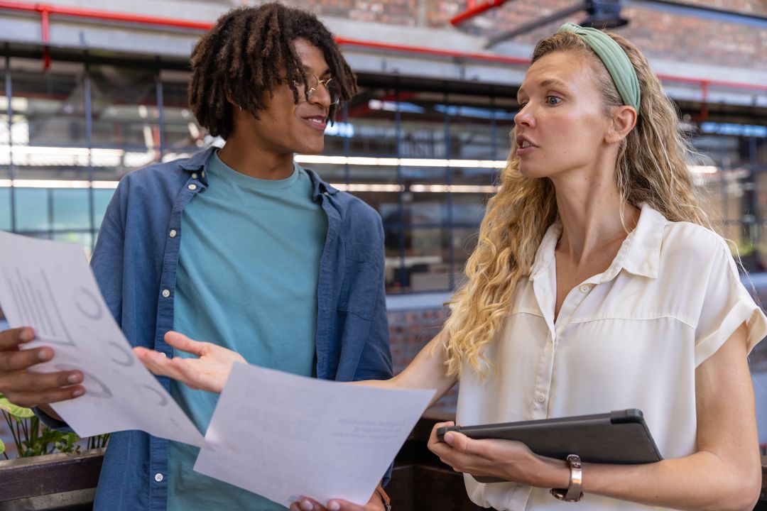 Diverse Coworkers Collaborating on Business Plans in Modern Office