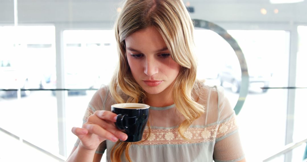 Young Woman Enjoying a Cup of Coffee in a Modern Cafe - Free Images, Stock Photos and Pictures on Pikwizard.com