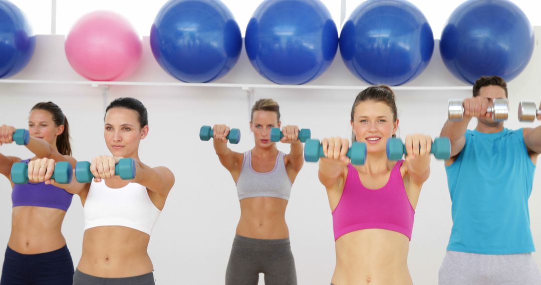 Group Exercise Class Lifting Dumbbells in Gym - Free Images, Stock Photos and Pictures on Pikwizard.com