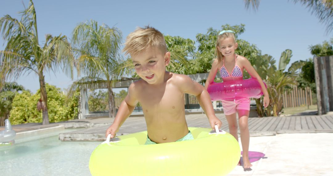 Happy Children Playing with Swim Rings at Poolside - Free Images, Stock Photos and Pictures on Pikwizard.com