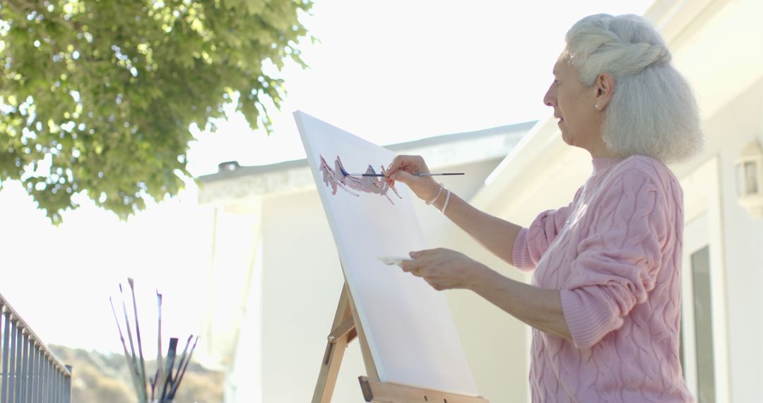 Elderly Woman Painting on Canvas Outdoors - Free Images, Stock Photos and Pictures on Pikwizard.com