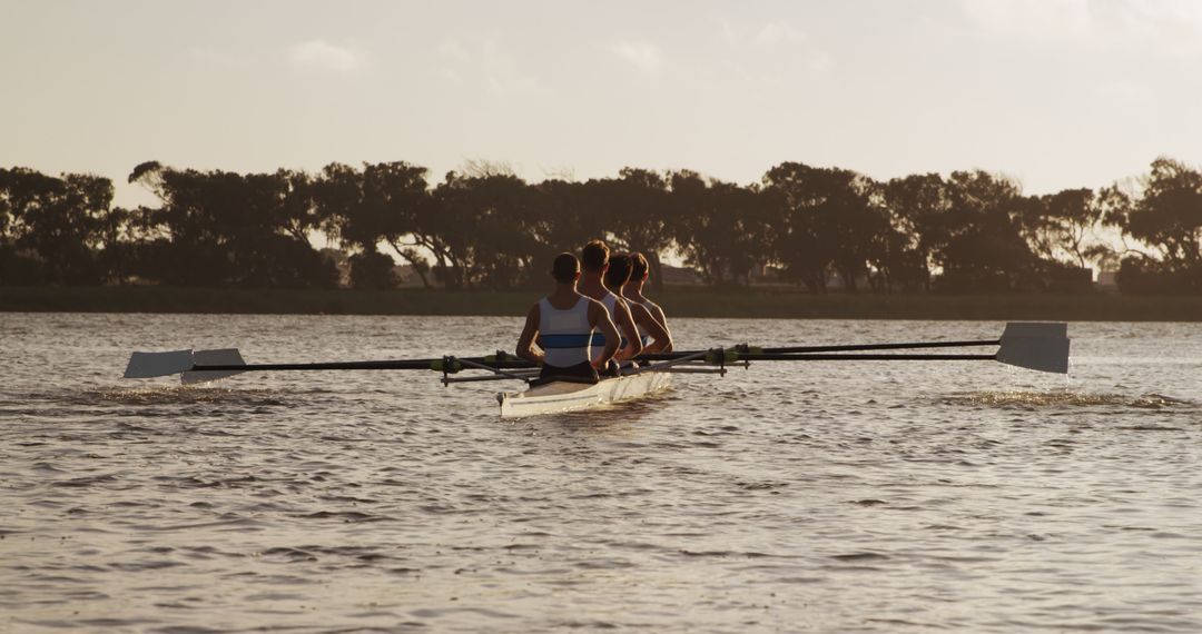 Rear View of Rowing Team on Calm Lake at Sunrise - Free Images, Stock Photos and Pictures on Pikwizard.com