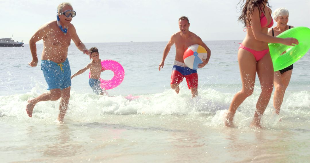 Multi-Generational Family Enjoying Beach Fun in Shallow Waters - Free Images, Stock Photos and Pictures on Pikwizard.com