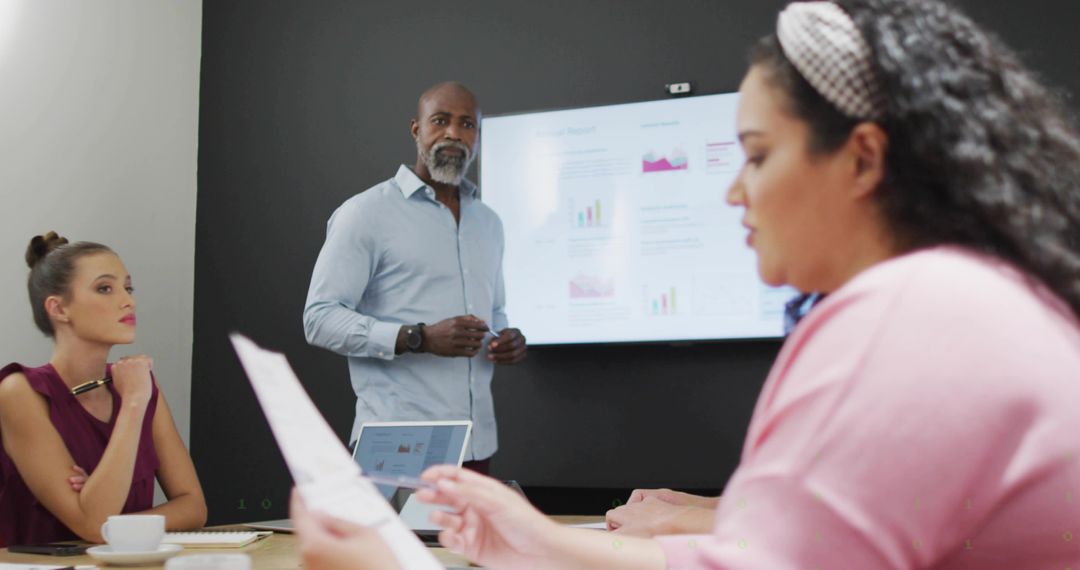 Senior manager presenting data to team during collaborative boardroom meeting with laptop analytics