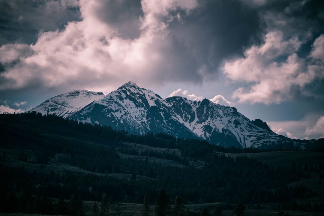 Snow-Capped Mountains with Dramatic Clouds and Dark Forest - Free Images, Stock Photos and Pictures on Pikwizard.com