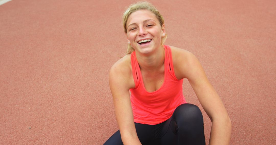 Smiling Athletic Woman Resting on Track After Workout - Free Images, Stock Photos and Pictures on Pikwizard.com