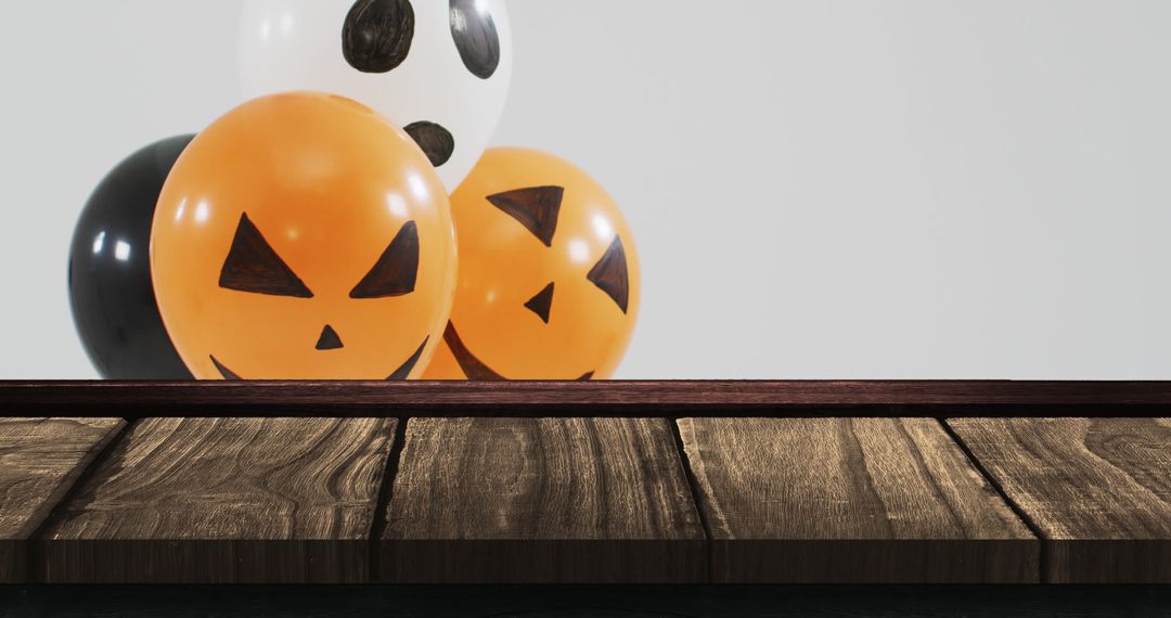 Halloween Balloons with Pumpkin Faces on Rustic Wooden Table