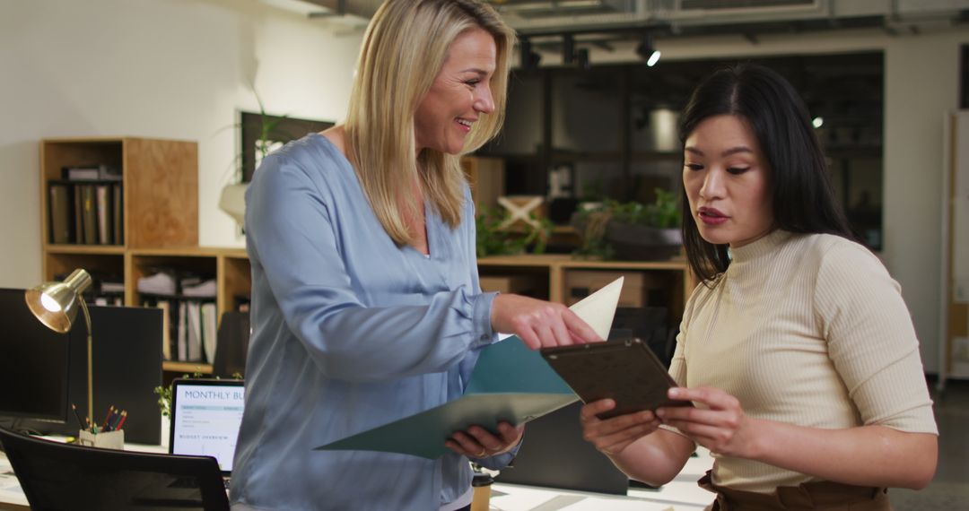 Businesswomen Discuss Documents in Modern Office Collaboration