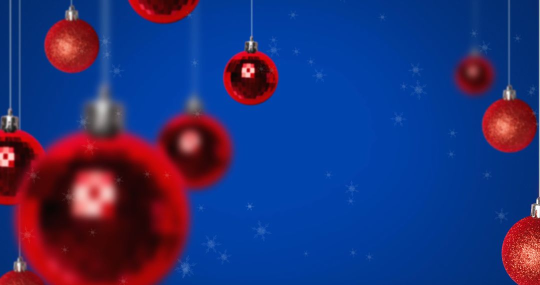 Festive Red Christmas Baubles on Blue Background with Falling Snowflakes