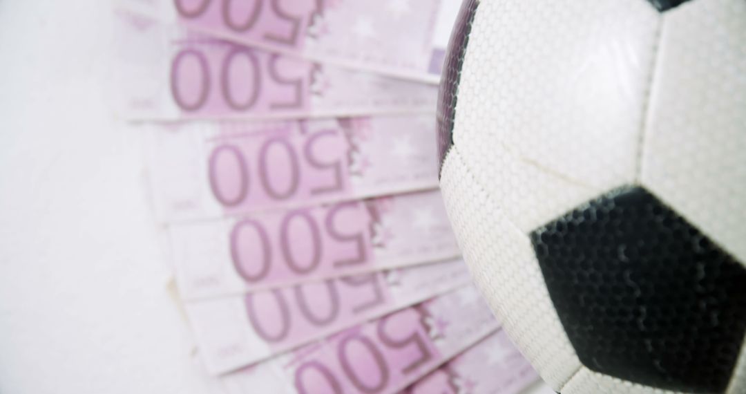 A soccer ball is prominently featured against a background of Euro currency notes, with copy space - Free Images, Stock Photos and Pictures on Pikwizard.com