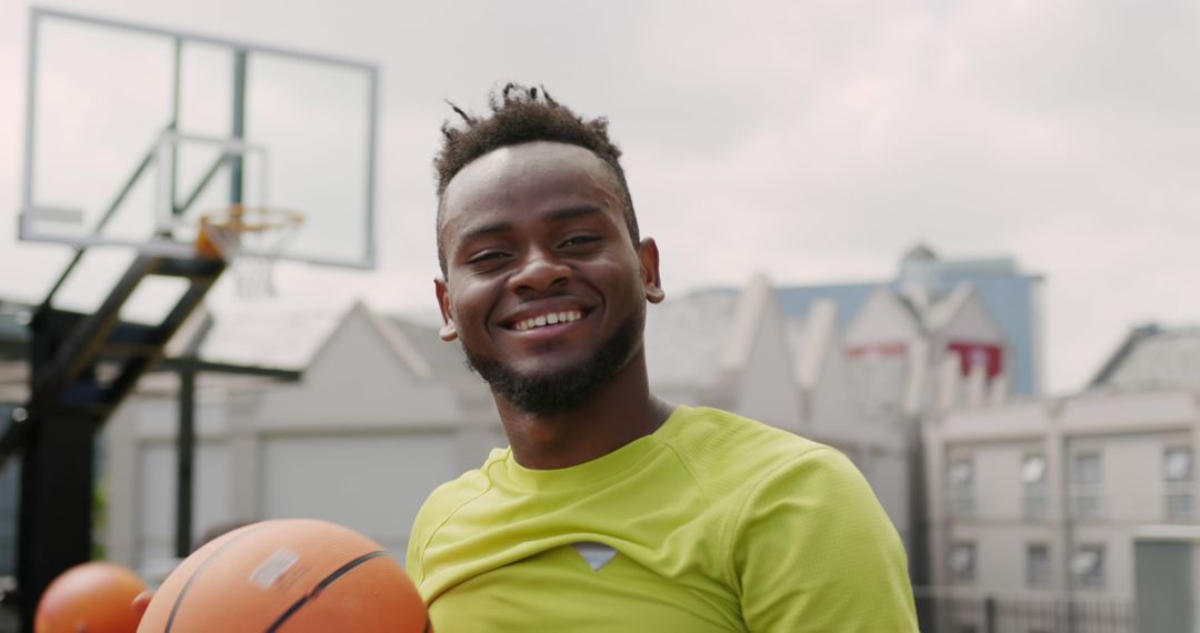 Smiling Young Man Holding Basketball on Outdoor Court - Free Images, Stock Photos and Pictures on Pikwizard.com